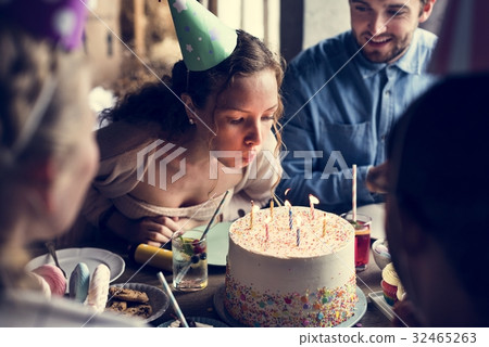 Woman Blowing Candles on Cake on Her Birthday Party Celebration Woman Blowing Candles on Cake on Her Birthday Party Celebration 32465263