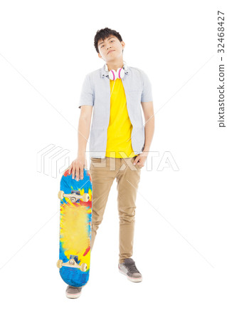 young man standing and holding a skateboard young man standing and holding a skateboard 32468427