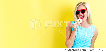 Happy young woman with cookie Happy young woman with cookie 32469717