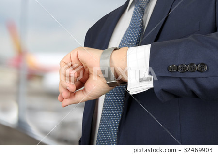 man checking time on his watch at the airport man checking time on his watch at the airport 32469903