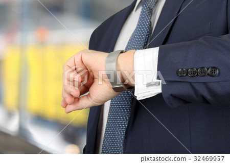 man checking time on his watch at the airport man checking time on his watch at the airport 32469957