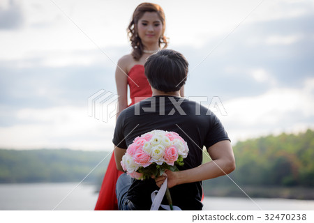 bouquet in the hands of a young man hidden behind. bouquet in the hands of a young man hidden behind. 32470238
