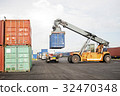 Forklift truck lifting cargo container in yard 32470348