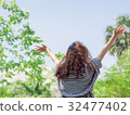 Girl raise hands up to the sky blurred background 32477402