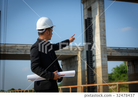 Asian young man engineers are holding a blueprint Asian young man engineers are holding a blueprint 32478437