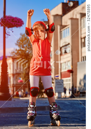 Pretty little girl in red cloth learning to roller 32478895