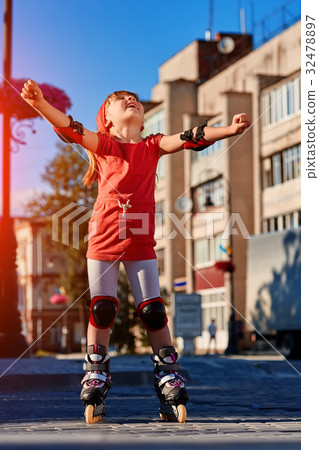Pretty little girl in red cloth learning to roller 32478897