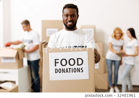 Energetic strong guy carrying a box with donations 32481961