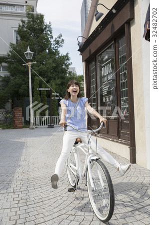 A woman bicycling down a slope A woman bicycling down a slope 32482702