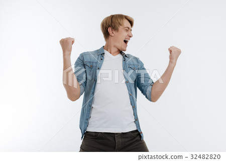 Satisfied young man raising his fists 32482820