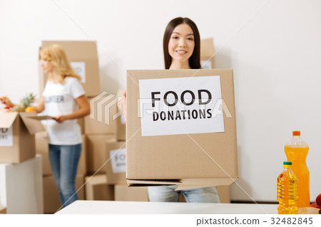 Wonderful young woman carrying a box with 32482845