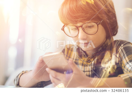 Cute clever kid holding his smartphone Cute clever kid holding his smartphone 32486135