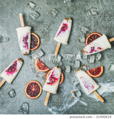 Blood orange, yogurt, granola popsicles on ice 32490629