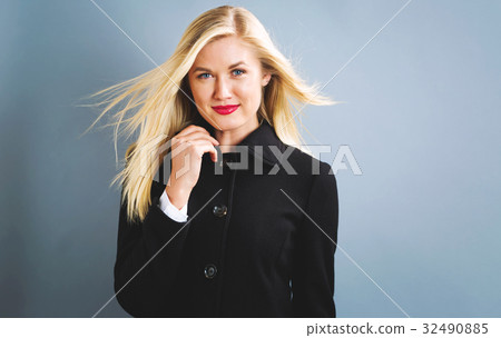 Beautiful blonde woman in a black coat 32490885