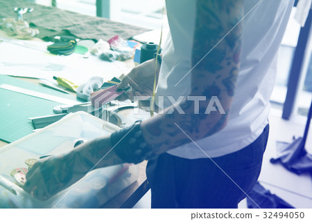 Fashion designer tattooed girl choosing material Fashion designer tattooed girl choosing material 32494050