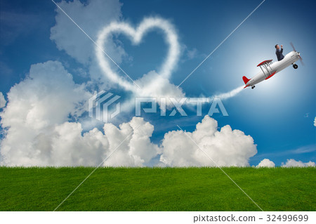 Man flying airplane and making heart shape 32499699