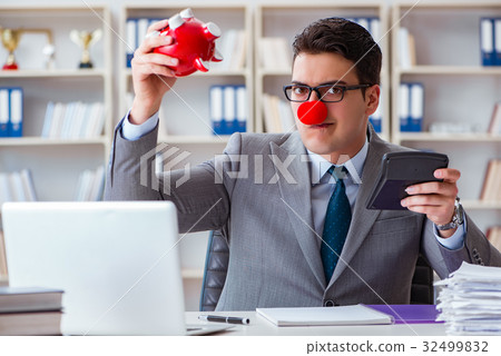 Clown businessman with piggy bank doing accounting 32499832