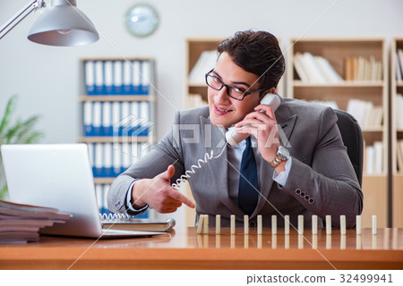Businessman with dominoes in the office 32499941