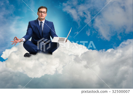 Businessman working on laptop in the sky Businessman working on laptop in the sky 32500007