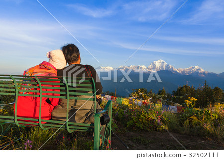 Tourist sit on bench look at the mountain. Tourist sit on bench look at the mountain. 32502111