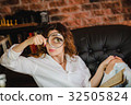 funny woman looking through a magnifying glass 32505824