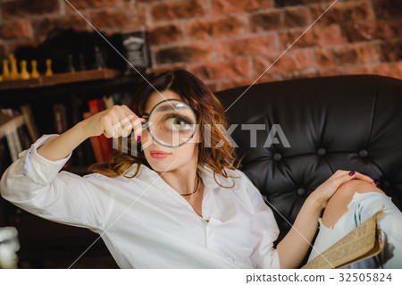 funny woman looking through a magnifying glass 32505824