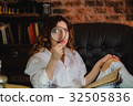funny woman looking through a magnifying glass 32505836