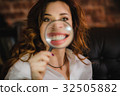 funny woman smiling and show teeth through a 32505882