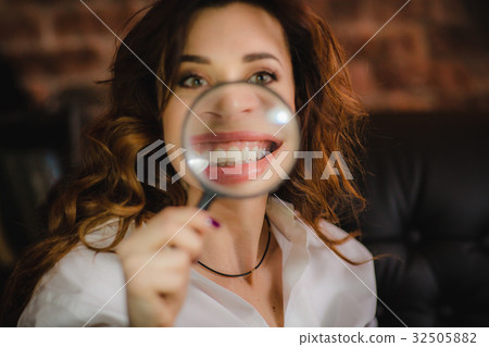 funny woman smiling and show teeth through a 32505882