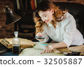 funny woman looking through a magnifying glass to 32505887