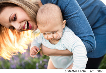 Young mother in nature with baby son in the arms. Young mother in nature with baby son in the arms. 32507868