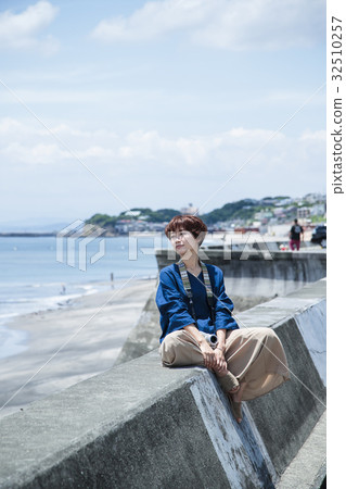 走的海女性照相機照相機防堤海岸旅遊業觀光的海灘 照片素材 圖片 圖庫