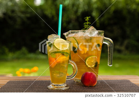 Homemade peach ice tea with lime and lemon balm Homemade peach ice tea with lime and lemon balm 32510707