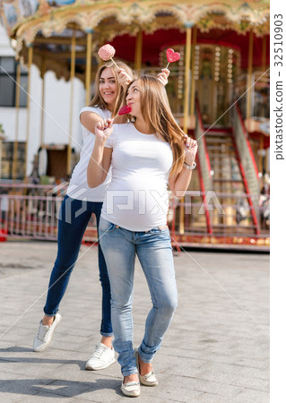 Two pretty women in amusement park having fun and Two pretty women in amusement park having fun and 32510903