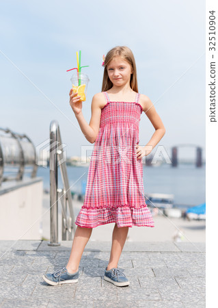 Little girl drinking fruit cocktail outdoors in Little girl drinking fruit cocktail outdoors in 32510904