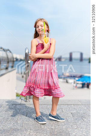 Little girl drinking fruit cocktail outdoors in Little girl drinking fruit cocktail outdoors in 32510906