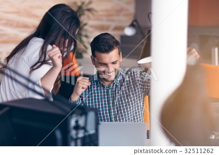 Young couple working together on a laptop in the Young couple working together on a laptop in the 32511262