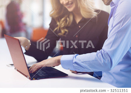 Young couple working together on a laptop in the Young couple working together on a laptop in the 32511351