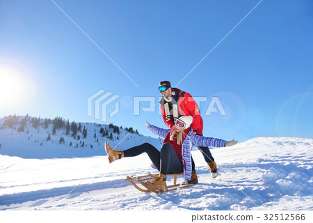 Young Couple Sledding And Enjoying On Sunny Winter 32512566
