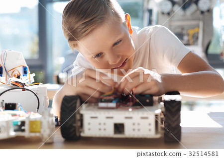 Adorable kid fixing wires in robotic vehicle Adorable kid fixing wires in robotic vehicle 32514581