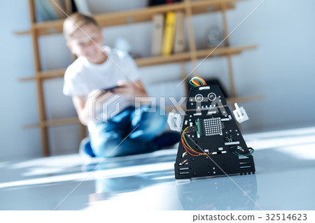 Fair-haired boy testing his new robot toy 32514623