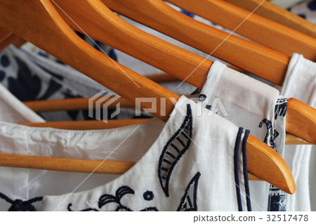 collection of women's clothes hanging on a rack collection of women's clothes hanging on a rack 32517478