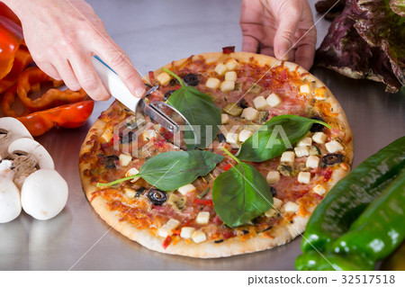 Cook cutting a pizza Cook cutting a pizza 32517518