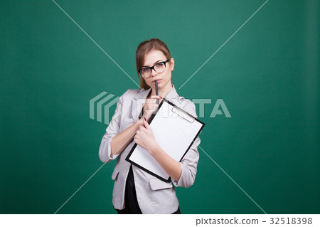 teacher with papers in green boards 32518398