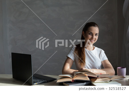 girl works at the computer reads a book at the 32518527