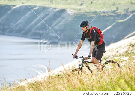 Attractive cyclist rirding mountain bike above 32520726