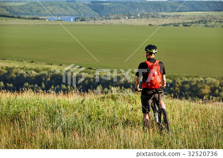 Rear view of the sportsman with his mountain bike Rear view of the sportsman with his mountain bike 32520736