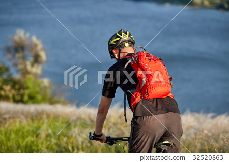 Young man riding mountain bike on the green meadow 32520863