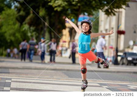 Funny Little pretty girl on roller skates in Funny Little pretty girl on roller skates in 32521391