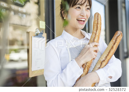 A woman with freshly baked French bread 32528372